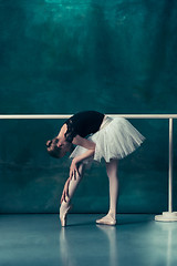 Image showing The classic ballerina posing at ballet barre