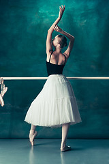 Image showing The classic ballerina posing at ballet barre