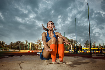 Image showing Female athlete performing a long jump during a competition