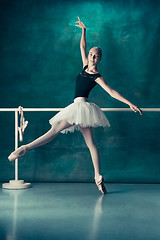 Image showing The classic ballerina posing at ballet barre