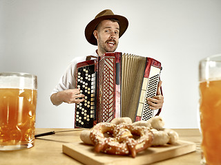 Image showing Man in traditional bavarian clothes playing accordion. Oktoberfest