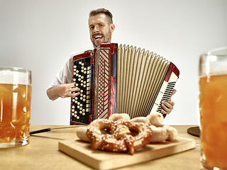 Image showing Man in traditional bavarian clothes playing accordion. Oktoberfest