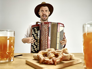 Image showing Man in traditional bavarian clothes playing accordion. Oktoberfest