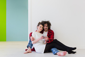 Image showing Young Couple using digital tablet on the floor