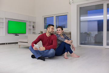 Image showing Young Couple using digital tablet on the floor