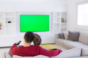 Image showing Young couple on the sofa watching television