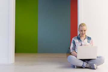 Image showing young woman using laptop computer on the floor