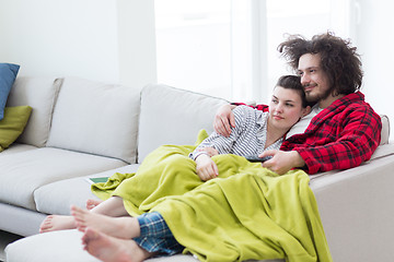 Image showing Young couple on the sofa watching television