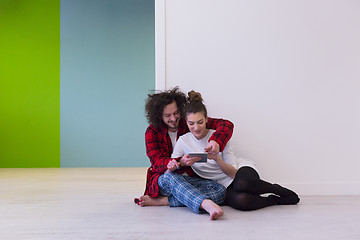 Image showing Young Couple using digital tablet on the floor