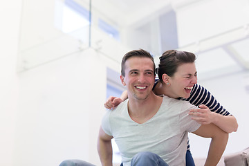 Image showing handsome man piggybacking his girlfriend