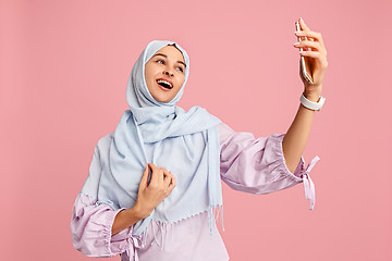 Image showing Happy arab woman in hijab. Portrait of smiling girl, posing at studio background