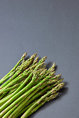 Image showing Pile of green organic asparagus on a grey background.