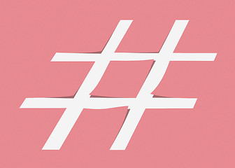 Image showing White hashtag symbol cut from pastel pink paper as a background.