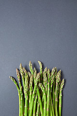 Image showing Heap of fresh natural asparagus on a gray background.