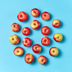 Image showing Organic apples round pattern on a blue background.