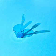 Image showing Plastic transparent glass with fork and knife with shadows on surface.