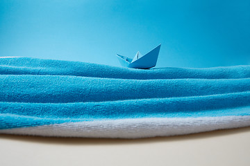 Image showing Waves of blue sea made from beach towel with paper boat.