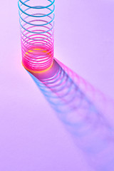 Image showing Stretching colored plastic slinky toy with shadows.
