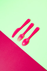 Image showing Dining set from colored plastic cutlery on a duotone background.