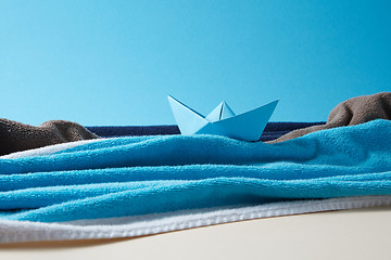 Image showing Seascape made from terry towels with paper boat and rocks.