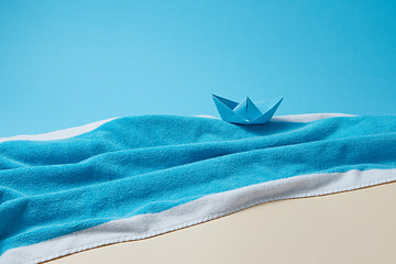 Image showing Paper boat on a terry blue towel as a seascape.