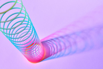 Image showing Rainbow plastic slinky toy with duotone shadows.