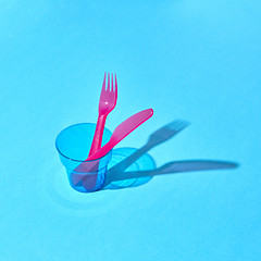 Image showing Served place with eating plastic utensil and glass with shadows.