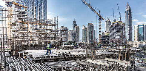 Image showing Laborers working on modern constraction site works in Dubai. Fast urban development consept