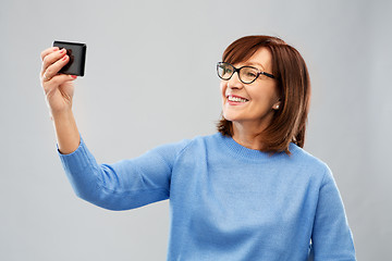 Image showing senior woman taking selfie by smartphone