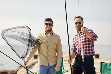 Image showing friends with fishing rod, fish and tackle on pier