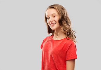 Image showing smiling teenage girl in red t-shirt winking