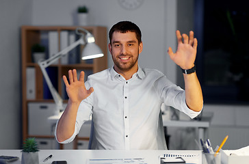 Image showing businessman using gestures at night office