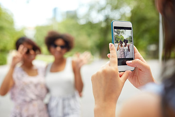 Image showing woman photographing her friends in summer park