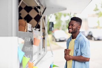 Image showing male customer looking at billboard at food truck