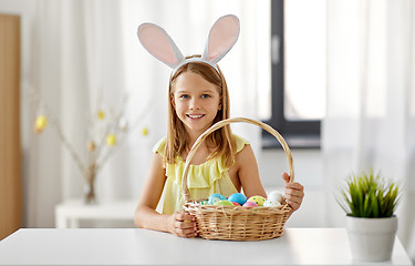 Image showing happy girl with colored easter eggs at home