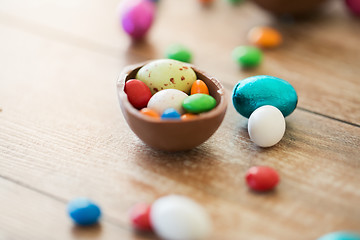 Image showing chocolate easter egg and candy drops on table