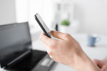 Image showing close up of hand with smartphone at office