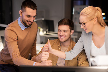 Image showing business team making thumbs up gesture at office