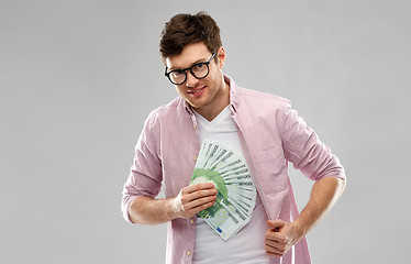 Image showing happy young man in glasses with fan of euro money