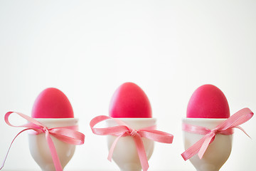 Image showing pink easter eggs in holders on white background