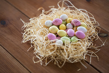 Image showing easter eggs in straw nest on wooden table