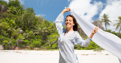 Image showing happy woman with shawl waving in wind on beach