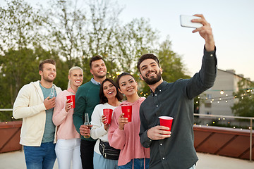 Image showing friends with drinks taking selfie at rooftop party