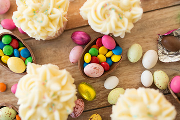 Image showing cupcakes with chocolate eggs and candies on table