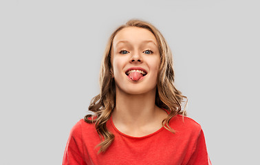 Image showing funny teenage girl in red t-shirt showing tongue