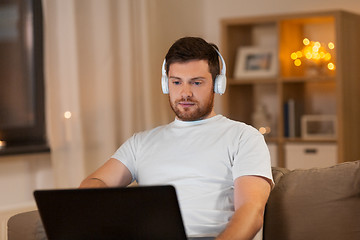 Image showing man in headphones with laptop computer at night