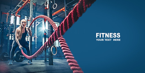 Image showing Woman with battle rope battle ropes exercise in the fitness gym.