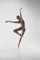 Image showing Ballerina. Young graceful female ballet dancer dancing at studio. Beauty of classic ballet.