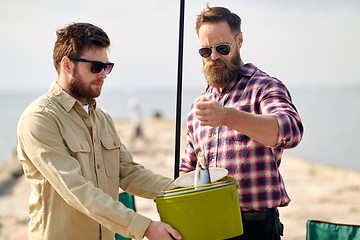 Image showing friends with fish, bucket and fishing rod on pier