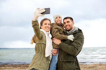 Image showing family taking selfie by smartphone on autumn beach